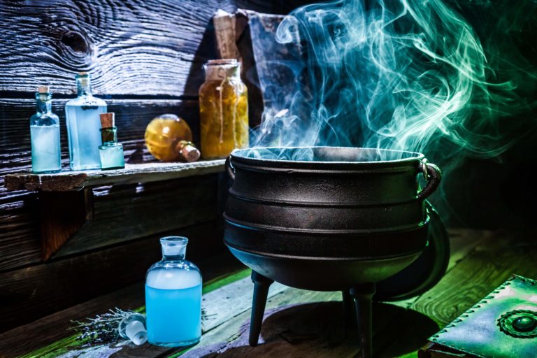 Vintage witcher cauldron with blue smoke and potions for Halloween ...